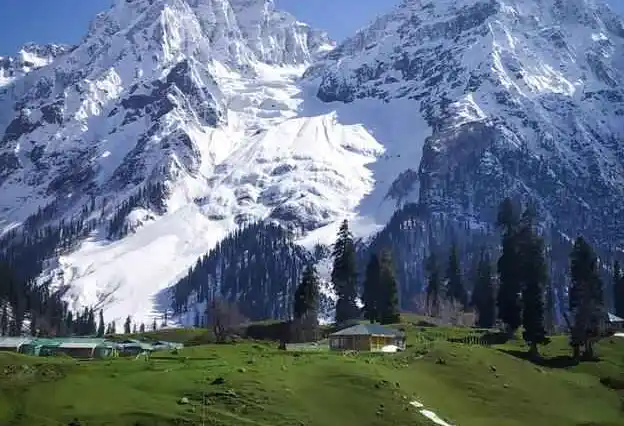 Sweeping panoramic view of Kashmir alpine valley and distant Himalayan snow peaks